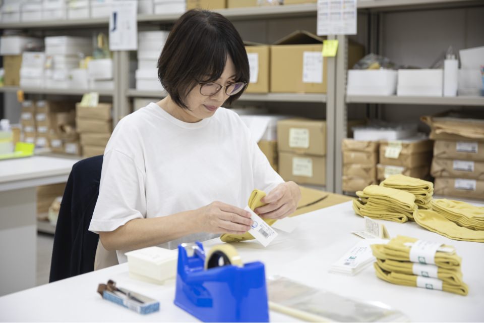 靴下にタグ付けを行う女性