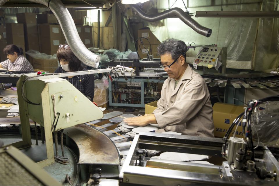 工場で靴下を作る社員