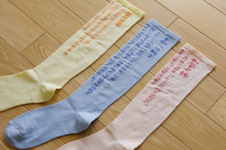 平和への祈りの文章が編み込まれた三足の靴下