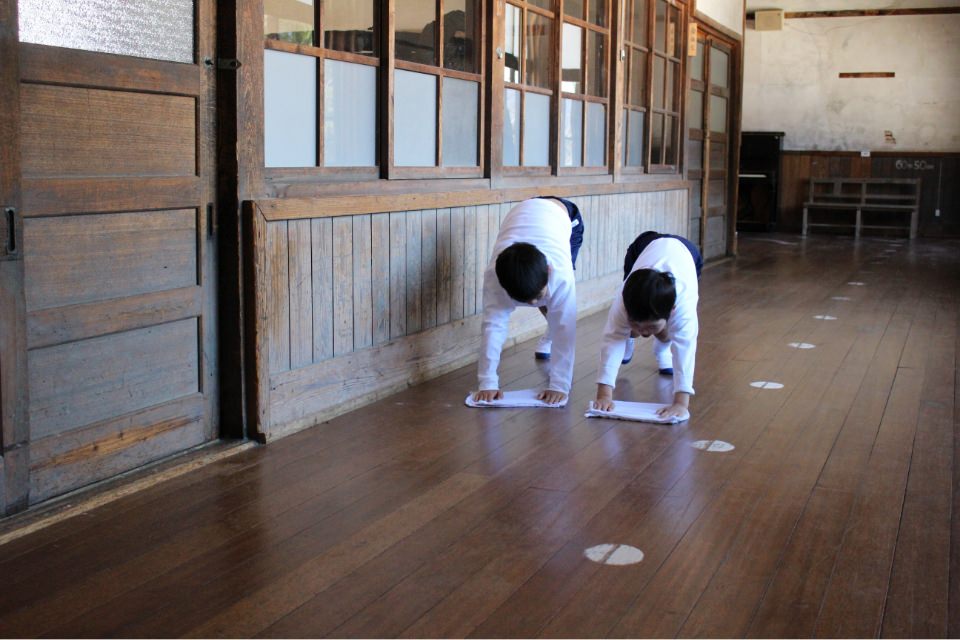 古い日本家屋で雑巾掛けをする二人の子供