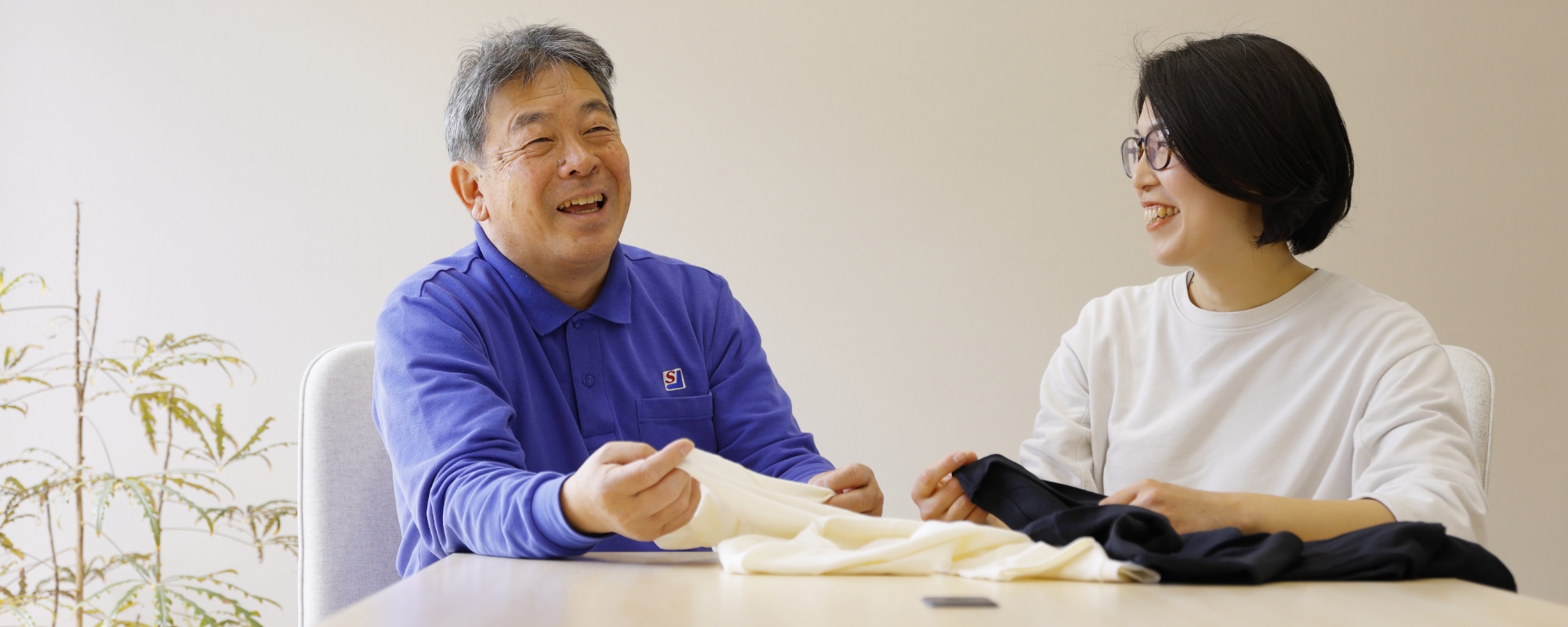 靴下生地を手に取りながら会話する男性と女性
