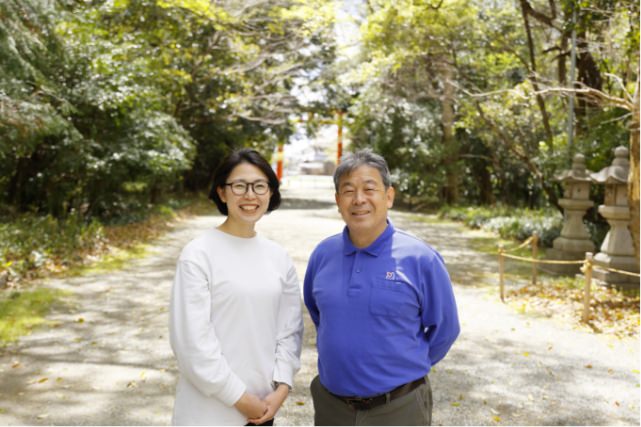 神社を背景に立つ代表親子