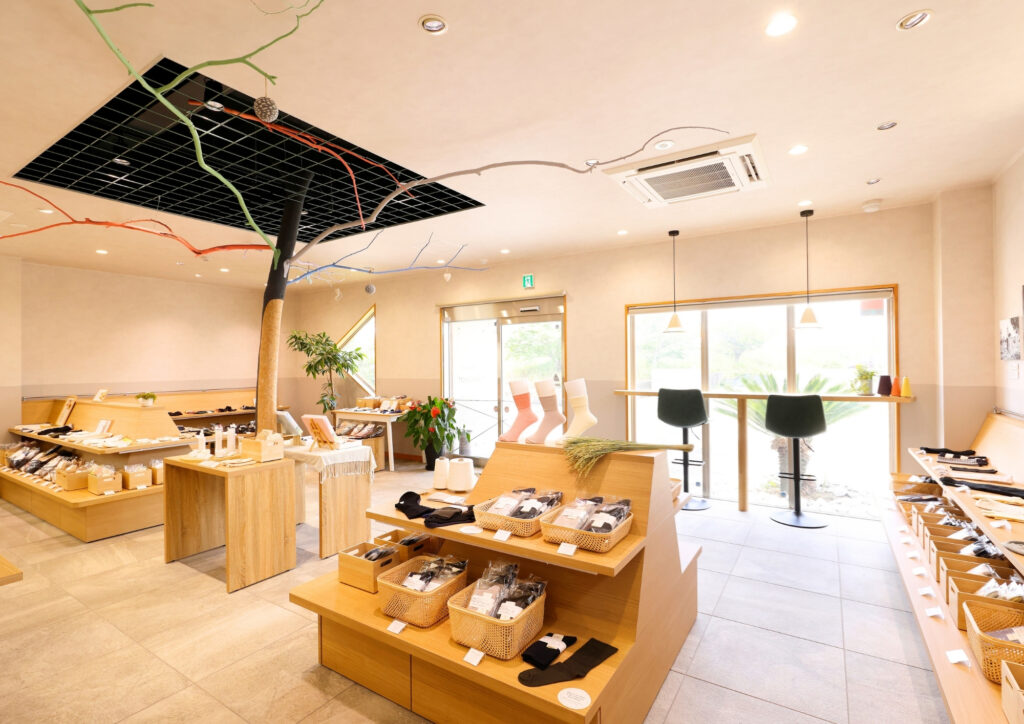 奈良県三宅町にある鈴木靴下直営店の店内。靴下や肌着などの商品が並ぶ、明るく落ち着いた雰囲気の店舗。